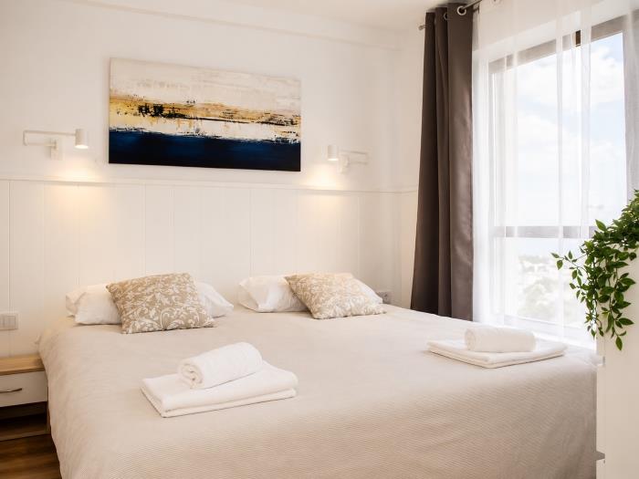 Dormitorio moderno y luminoso con cama doble y ambiente acogedor para descansar.