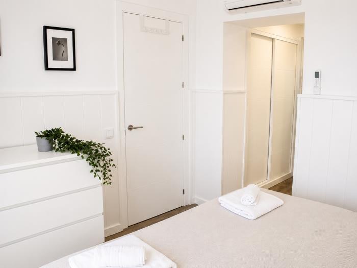 Dormitorio moderno y luminoso con aire acondicionado, decoración elegante y ambiente acogedor.