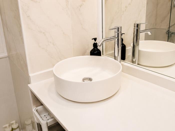 Baño moderno con lavabo elegante, acabados minimalistas y diseño funcional para mayor comodidad.