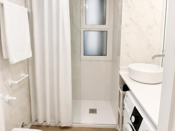 Baño moderno con ducha, lavabo elegante y diseño funcional luminoso para una estancia cómoda.