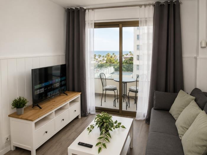 Salón moderno con Smart TV, terraza privada, vistas al mar y ambiente relajante.