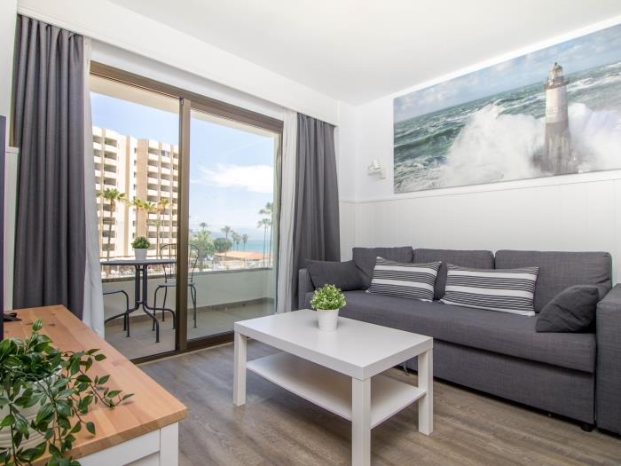 Salón moderno con terraza privada, vistas al mar y ambiente relajante cerca de la playa.