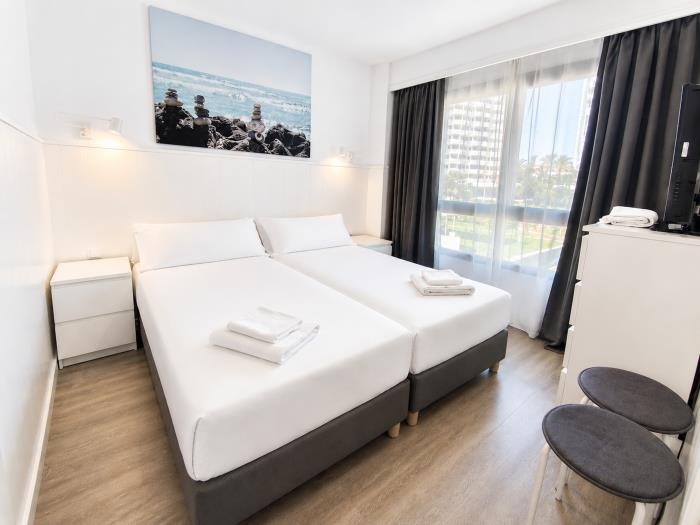 Dormitorio moderno y luminoso con camas individuales y ambiente acogedor para descansar.