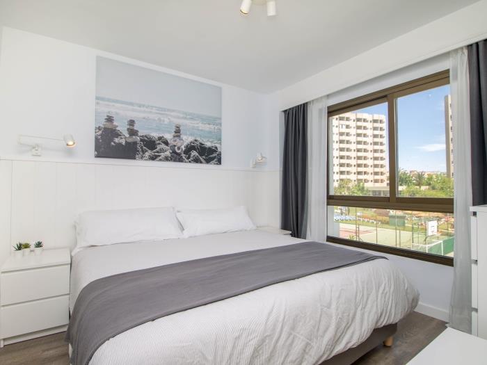 Dormitorio moderno y luminoso con cama doble y ambiente relajante cerca de la playa.
