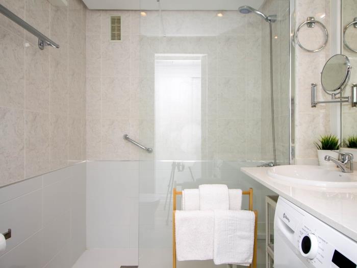 Baño moderno con ducha amplia, acabados elegantes y diseño funcional para mayor comodidad.