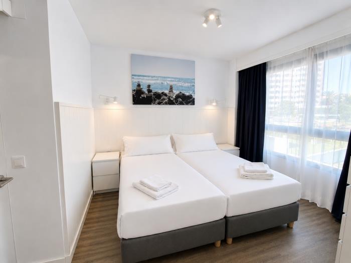 Dormitorio moderno y luminoso con camas individuales y ambiente acogedor para descansar.