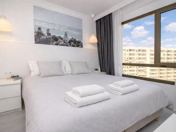 Dormitorio moderno y luminoso con cama doble y ambiente relajante cerca de la playa.