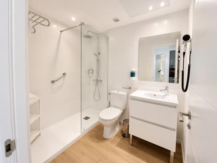 Baño moderno con ducha amplia, acabados elegantes y diseño funcional para mayor comodidad.