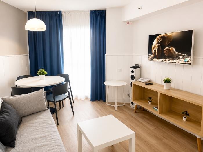 Salón moderno y luminoso con zona comedor, Smart TV y ambiente acogedor cerca de la playa.