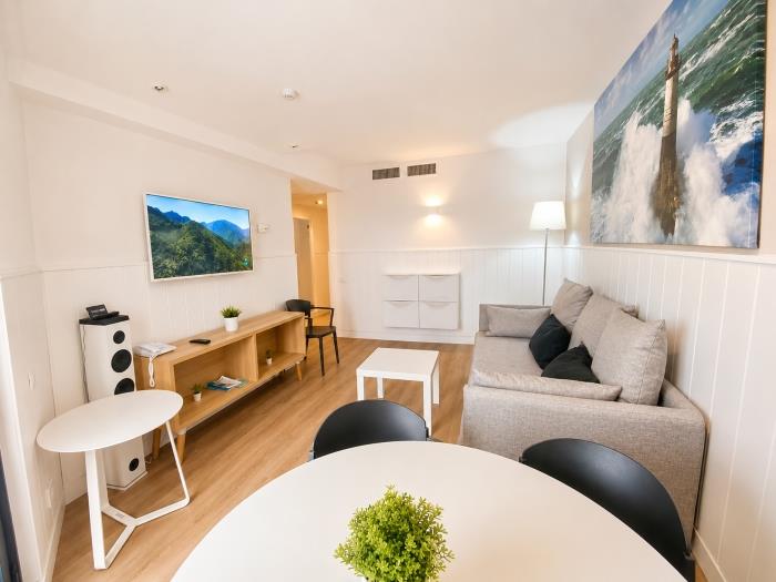 Apartamento moderno y luminoso con salón acogedor, Smart TV y decoración elegante.