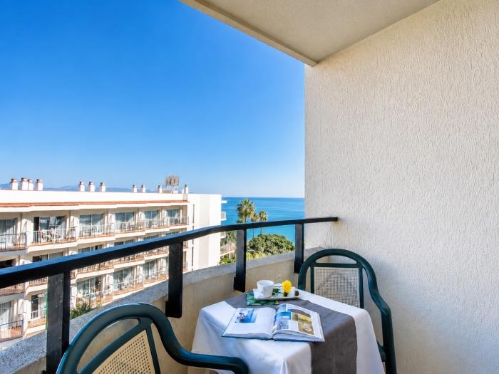 Terraza privada con vistas al mar y mesa exterior ideal para relajarse cerca de la playa.