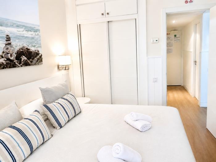 Dormitorio moderno y luminoso con cama doble, armario empotrado y ambiente acogedor.