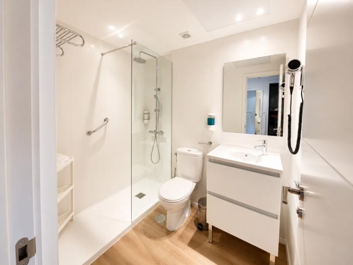 Baño moderno con ducha amplia, acabados elegantes y diseño funcional para mayor comodidad.