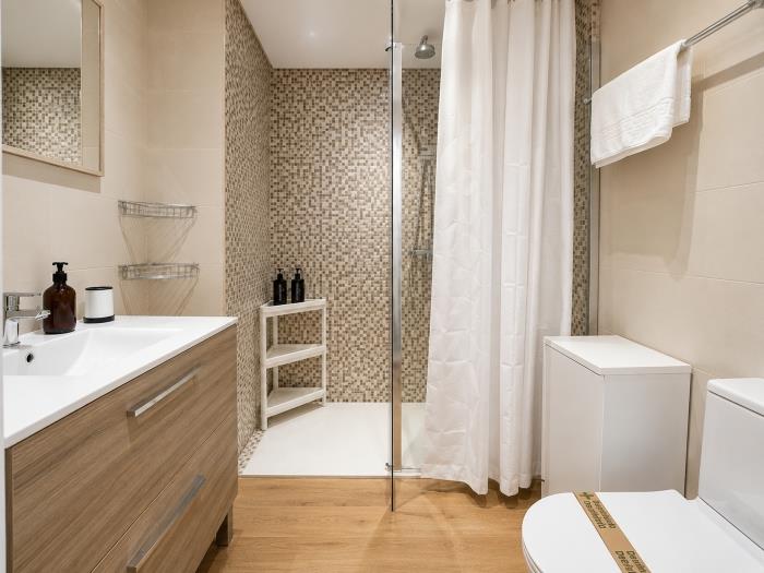 Baño moderno con ducha amplia, acabados elegantes y diseño funcional para una estancia cómoda.