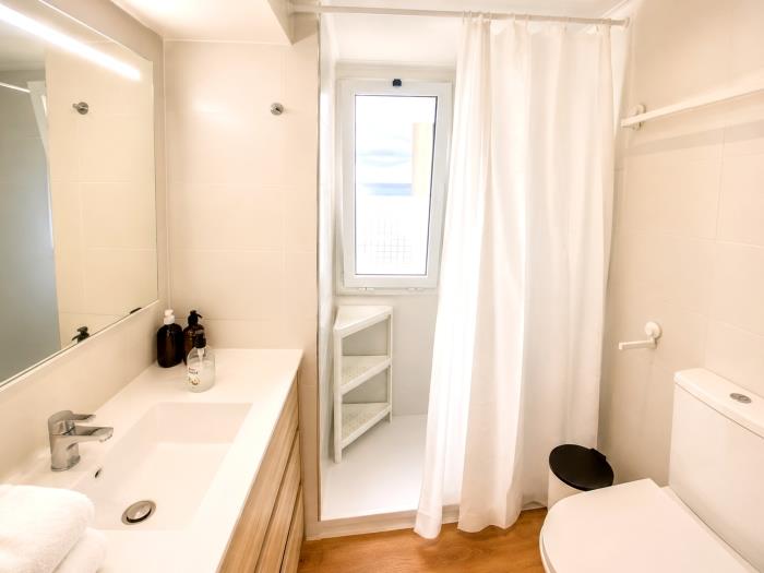 Modern bathroom with shower, elegant sink and bright functional design for comfortable stays.