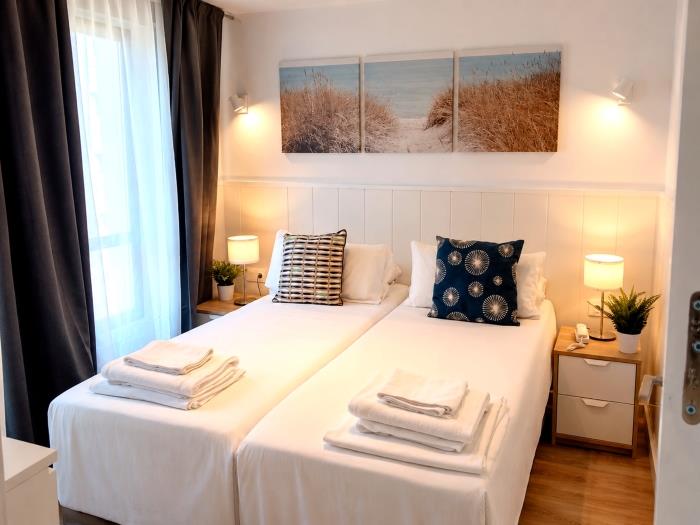 Bright modern bedroom with twin beds, elegant décor and cozy atmosphere for relaxing stays.
