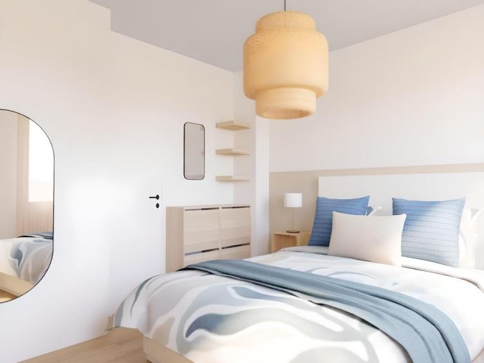 Dormitorio moderno y luminoso con cama doble, decoración elegante y ambiente relajante.